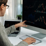 Investors pointing interesting stock exchange on pc with laptop
