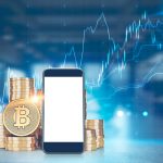 Pile of bitcoins with a large mock up screen smartphone in the foreground