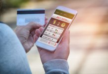 Man betting on sports, holding smart phone with working online betting mobile application